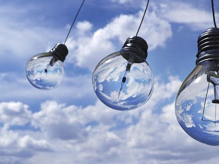 Drei Glühbirnen hängen am blauen Himmel - Neue Ideen für die Zukunft