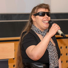 Kevienella, blinde Sängerin mit Sonnenbrille und Mikrofon