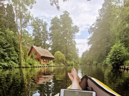 Mensch mit Tablet in Boot auf Fluss
