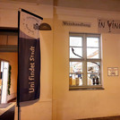 Aussenfassade der Weinhandlung „In Vino“ mit Beachflag von „Uni findet Stadt“