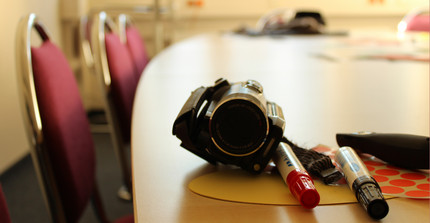 Camcorder and pens as a symbol for the innovative teaching methods in Docendo Discimus