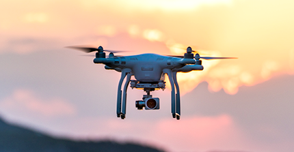 fliegende Drohne vor Himmel mit Sonnenuntergangsstimmung