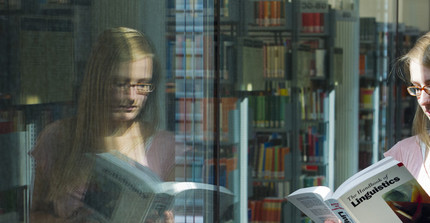 Young woman at a window with book