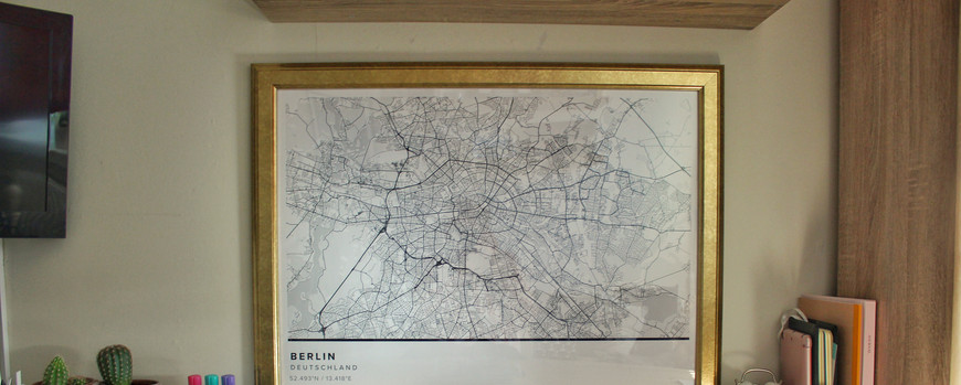 Über einem Schreibtisch hängt ein Stadtplan von Berlin
