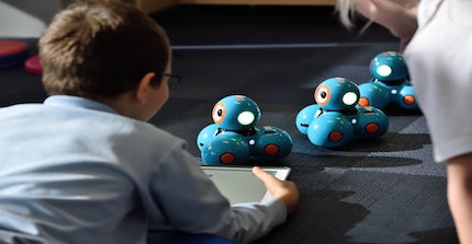 Kind spielt mit Robotern