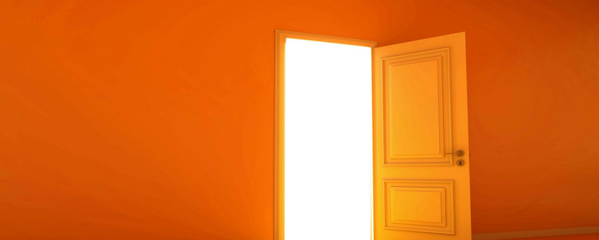 Eine orange Tür, die offen steht und durch die Licht hereinscheint