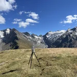 Field site Hohe Mut: A laser scanner on tripod on a alpine meadow, overlooking an alpine crest with sparse remainders of snow | Photo: Cosmic Sense Consortium