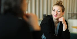 Dr. Anna Finzel im Interview auf einem Sofa sitzend.