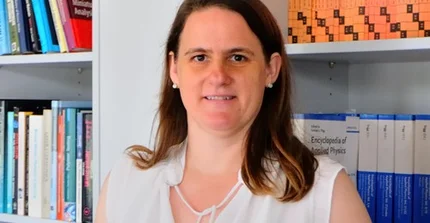 Mrs. Prof. Hoffmann-Vogel in front of a bookshelf