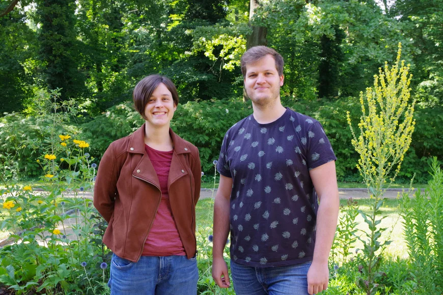 people standing in front of flowers and trees