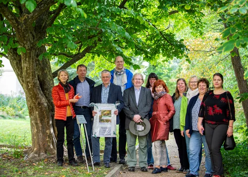 Gruppe der Anwesenden bei der Übergabe der Pflanzenpatenschaft an Frau Schmid neben der Parrotia
