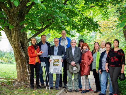 Gruppe der Anwesenden bei der Übergabe der Pflanzenpatenschaft an Frau Schmid neben der Parrotia