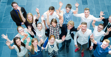 Gruppe von Schülern winkend von oben fotografiert