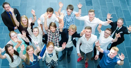 Gruppe von Schülern winkend von oben fotografiert