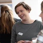 Mehrere Professorinnen sprechen und lachen miteinander.
