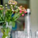 Blumen, Wasser und Kekse auf einem Bürotisch stehend