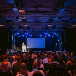 Veranstaltungsraum mit Bühne und Publikum davor
