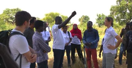 GreenGaDe members are standing together and one is directing the others
