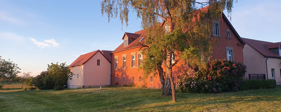 Das Backsteinhauptgebäude wird vom Sonnenuntergang angestrahlt - 