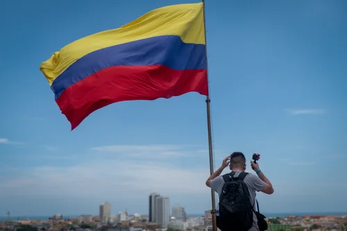 Die Flagge Kolumbiens und eine Person mit einem Rücksack