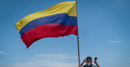 Die Flagge Kolumbiens und eine Person mit einem Rücksack