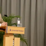 Präsident Prof. Oliver Günther, Ph.D. begrüßt die Absolvent*innen an einem Rednerpult auf der Bühne.