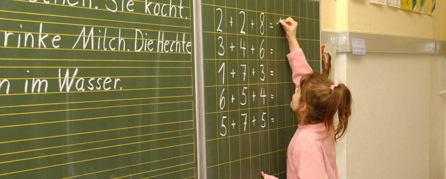 Schülerin rechnet an der Tafel