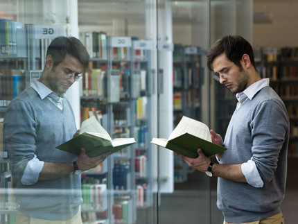 Ein Student liest ein Buch in der Bibliothek.