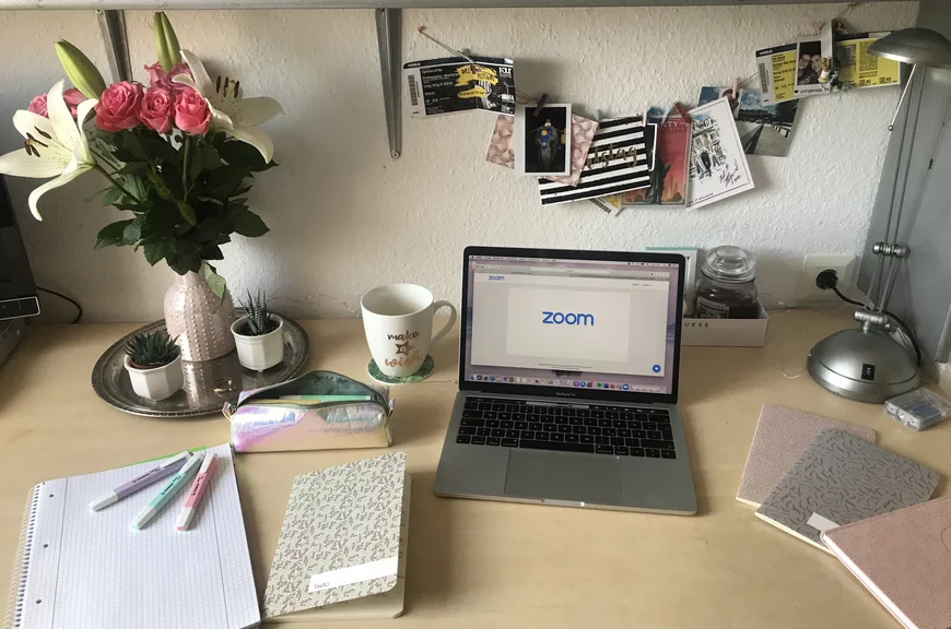 Schreibtisch mit Blumen, Laptop und Notizbüchern
