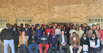Group pictures of farmers, researchers and other stankeholders standing in front of a building