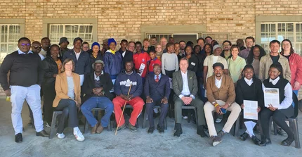 Group pictures of farmers, researchers and other stankeholders standing in front of a building