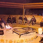 Menschen sitzen am Abend um ein Feuer