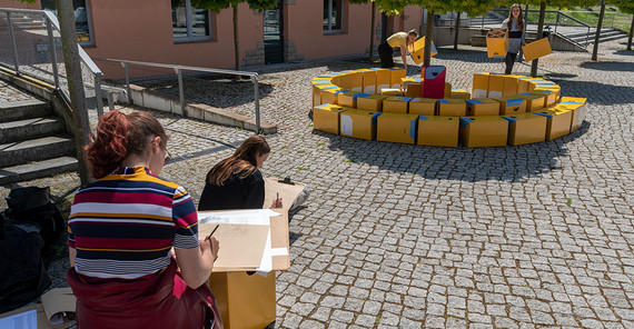 In drei Gruppen verbauen sie Pappwürfel der Bundesstiftung Baukultur.