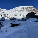 Field site Dresdner Hütte: Measuring equipment installed at a hillslope and the chalet Dredner Hütte in winter, with rocky mountain top in the background | Photo: Cosmic Sense Consortium