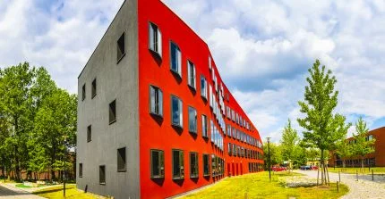 Ein rotes Gebäude, das eine wellenförmig geschwungene Fassade hat