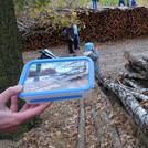 Foto-Puzzle wird bei im Wald liegenden Baumstämmen hochgehalten