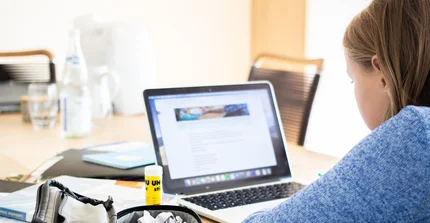 Ein Mädchen sitzt vor dem Laptop