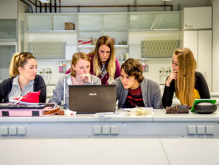 Studenten sitzen um einen Computer herum. Foto: Karla Fritze