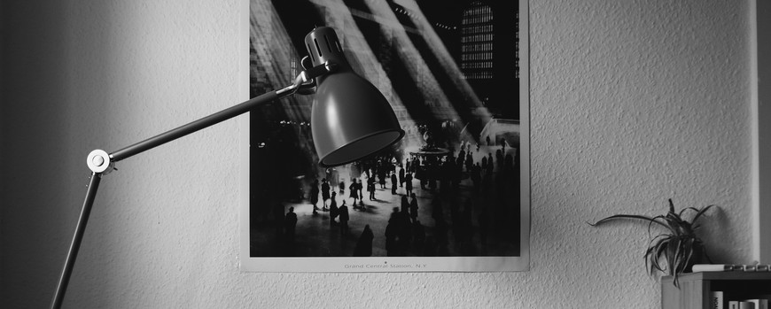 Laoptop auf Tisch mit Poster an Wand. Schwarz Weiß Aufnahme