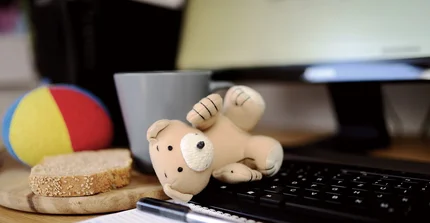 Spielzeug und Butterbrot vor einem Computer