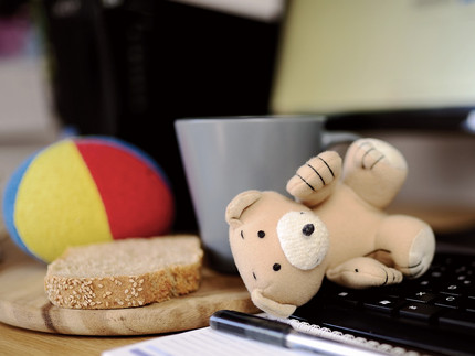 Spielzeug und Butterbrot vor einem Computer