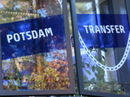 Minimal geöffnetes Glasfenster mit Klebefolie in Blau und Aufschrift Potsdam Transfer