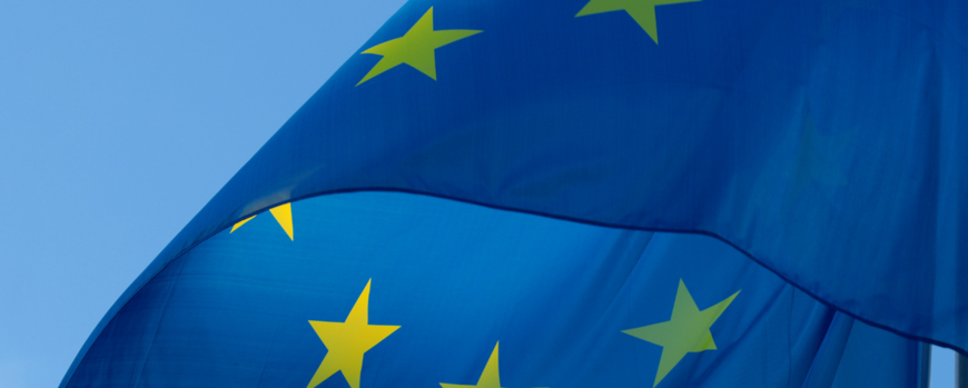 Es ist eine wehende Europafahne (Ausschnitt) zu sehen. Das Bild stammt von Canva.