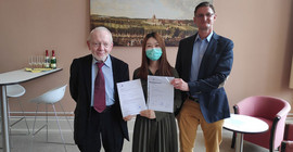 Die erste Absolventin im Master „Interkulturelle Wirtschaftskommunikation“ Xinyi Xu erhält von Studiengangsleiter Prof. Dr. Thomas Stehl (l.) und dem Dekan der Philosophischen Fakultät Prof. Dr. Hans-Georg Wolf ihre Abschlussurkunde. | Foto: Matthias Zimmermann