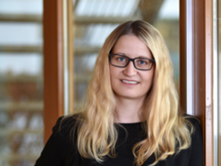 Dr. Katharina Stein (standing in front of a building)