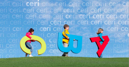 Kinder mit Buchstaben unter dem Arm laufen über den Rasen