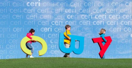 Kinder mit Buchstaben unter dem Arm laufen über den Rasen