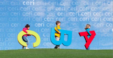 Kinder mit Buchstaben unter dem Arm laufen über den Rasen