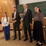 Auf dem Bild sieht man die Gäste der Podiumsdiskussion mit einem Blumenstraußübergabe