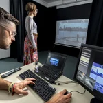This image shows two people during an experiment that measures eye movement.